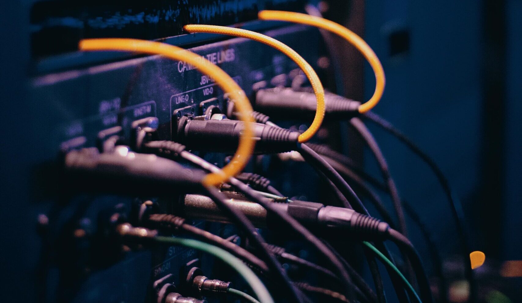 Close-up of network cables and ports in a server rack, showcasing connectivity.